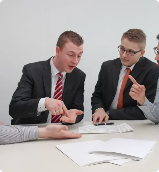 Business professionals discussing contracts in a modern office setting.